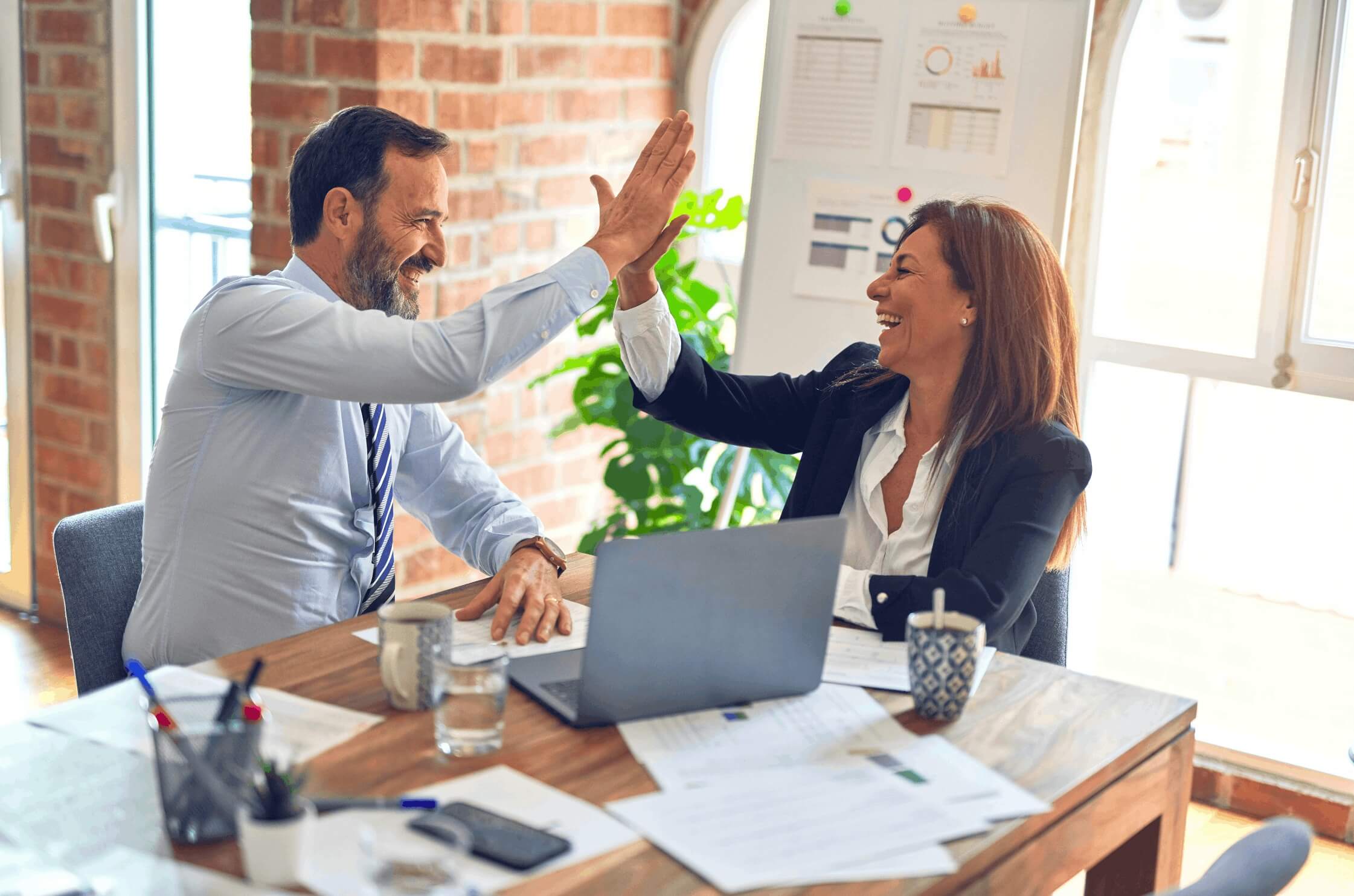 Two colleagues celebrating a successful planning session with a high five.